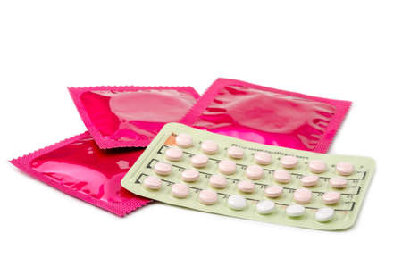 Strip of Contraceptive Pill and condoms on whie background.の写真素材
