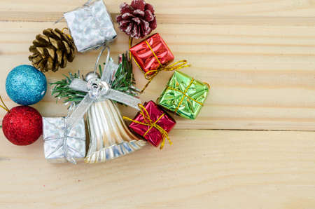Silver bell and christmas decorations on wood background.