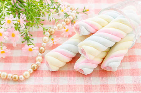 Twisted marshmallow with flower on tablecloth background.の写真素材