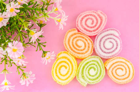 Jelly sweet, flavor fruit, candy dessert colorful with flower on pink background.の写真素材