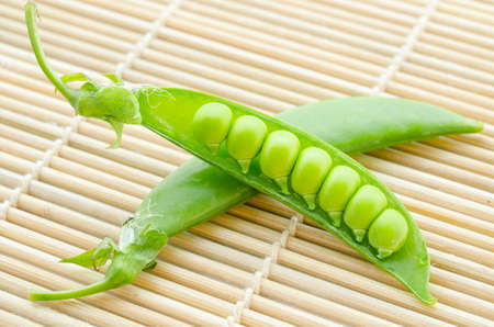resh green peas vegetable on mat wood board