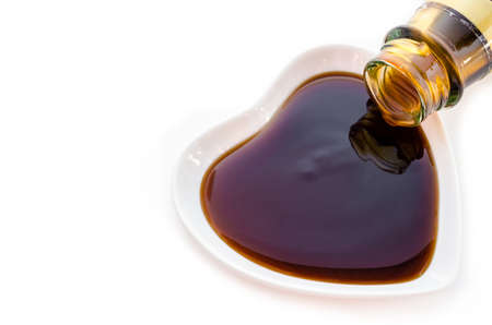 Oyster sauce in white cup heart shape on white background.の写真素材