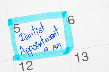 Hand writes reminder Calendar mark with Dentistの写真素材