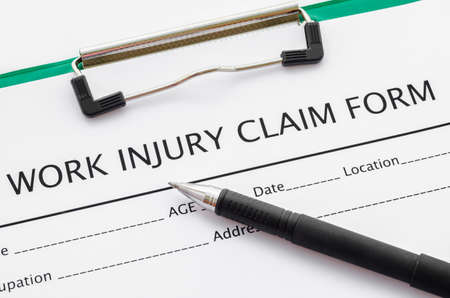 Claim form for an injury at work with pen.の写真素材