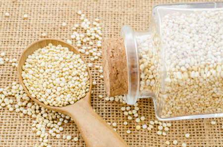 Chenopodium quinoa seeds in wooden spoon on white background.の写真素材