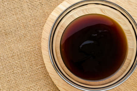 Oyster sauce in glass bowl on sack background.