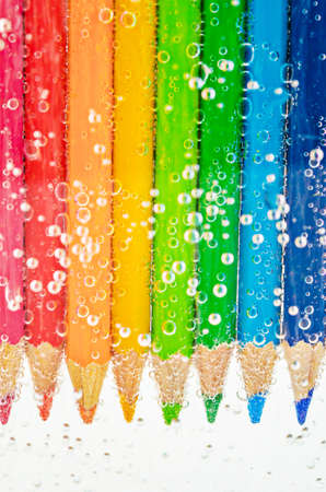 Close up colorful wooden pencils in sada water with bubblesの写真素材
