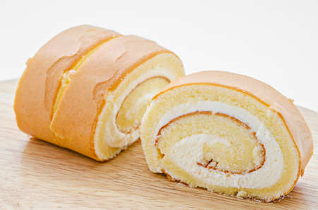 Roll cake on wooden dish.の写真素材