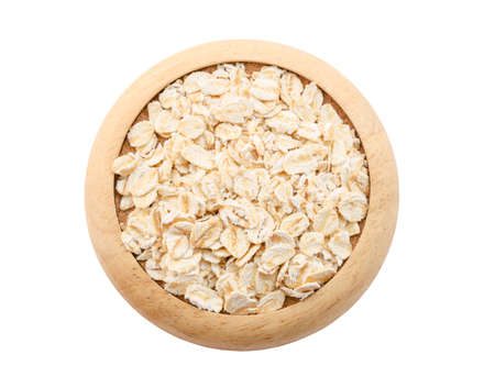 Oat flakes pile in wooden dish isolated on white background