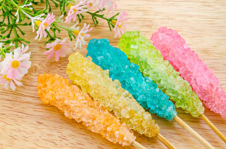 Many colorful sugar crystal candy on wooden stickの写真素材