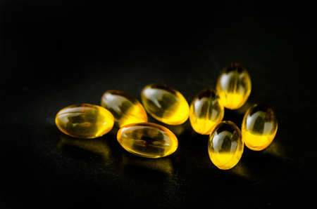 Fish oil omega 3 gel capsules on black background.の写真素材