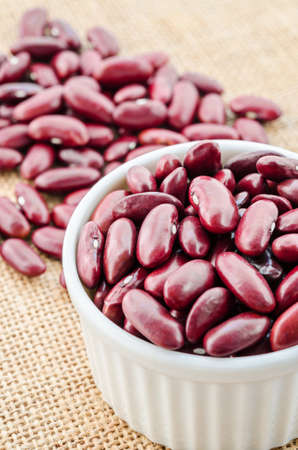 Kidney beans seeds in white bowl on sack background.