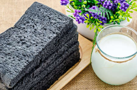 Sliced Charcoal bread black bread served with milk in a glass jar.の写真素材