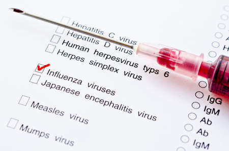 Red mark on Influenza virus screening form test with sample blood in syringe.の写真素材