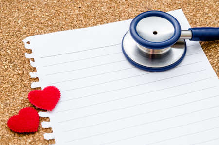 Blank paper note with stethoscope with red heart ready for your text or message on wood background.の写真素材