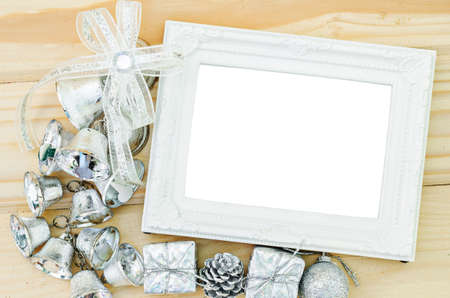 Blank vintage white photo frame with silver decoration christmas on wooden background.の写真素材