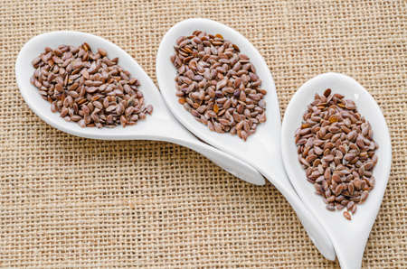 linseed photo of on white spoon on sack background.の写真素材