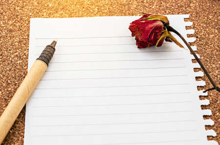 Open empty diary paper and dry rose with pen on woon background, Ready for your text or message.の写真素材