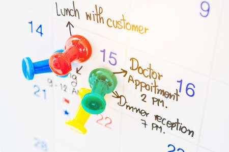 Pushpin on calendar with busy day overworked schedule.の写真素材