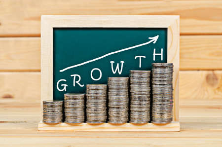 Money graph with Growth on chalkboard in wooden room. Business growth concept.の写真素材