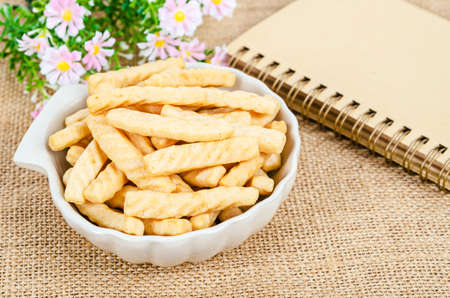 crunchy prawn crackers on cup wish diary on sack background.