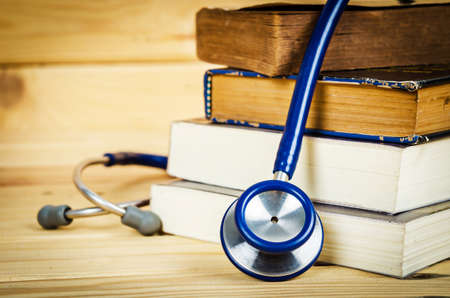 Stethoscope and old books on wooden background.の写真素材