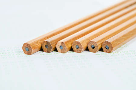 Wooden pencils on answer sheets or test paper background.の写真素材