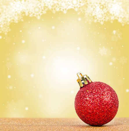 Glitter red ball on christmas yellow background.の写真素材