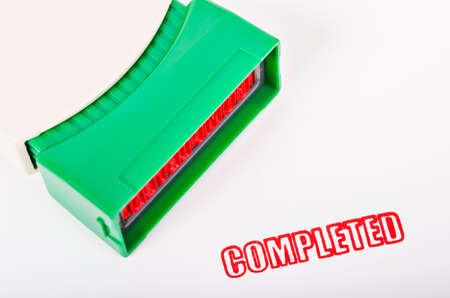 Rubber stamping that says red color completed on white background.の写真素材