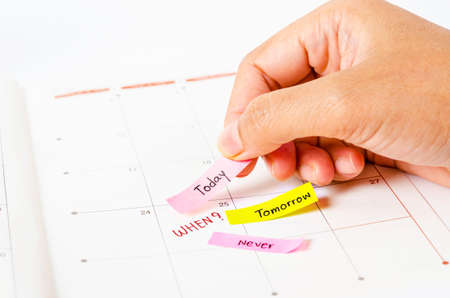 Hand Choosing the right date time management on calendar page.