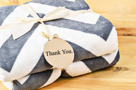 Blanket with Thank you tag gift with ribbon on wooden background. Gift Concept.の写真素材