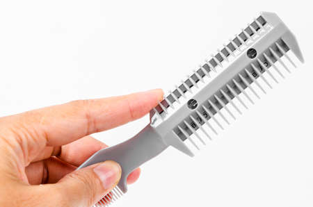 Hand woman holding Comb slice hair with blade isolated on white background.