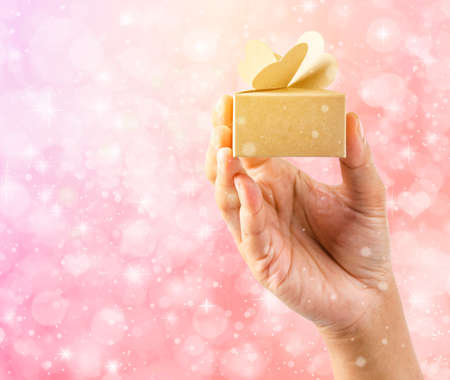 Hands holding brow gift box with magical special effects lights.の写真素材