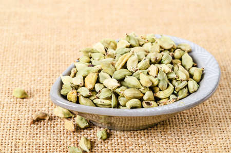 Green cardamon in cup on sack background.の写真素材