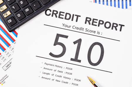 Credit score report with calculator and pen on business report document.の写真素材
