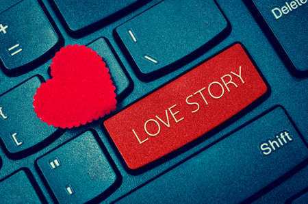 Computer keyboard and red heart with word LOVE STORY.の写真素材