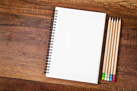 Open blank notebook with many wooden pencils on wood table for background.の写真素材