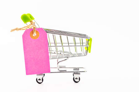 Blank pink paper price tag with shopping cart isolated on white background