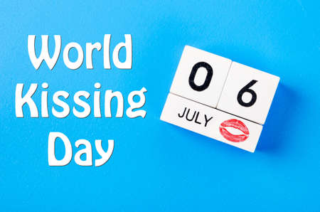 World kissing day concept of july 6 wooden color calendar on blue background.