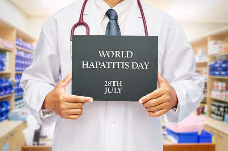 STOP HEPATITIS on chalkboard in doctor hand. World Hepatitis day concept.の写真素材