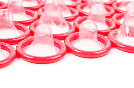 Red condom with open pack on white background.の写真素材