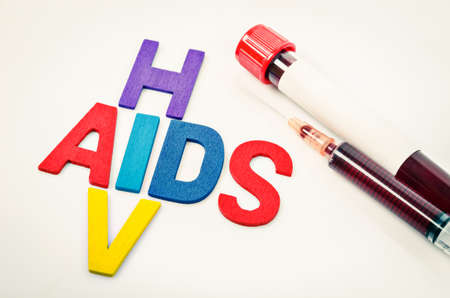 AIDS and HIV crossword with sample blood in blood tube.