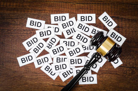 One gavel like those used on auctioning with the word bid on wooden background.の写真素材