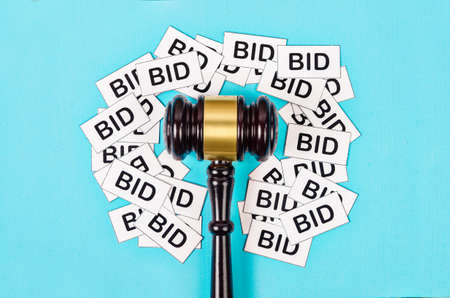 One gavel like those used on auctioning with the word bid on blue background.の写真素材
