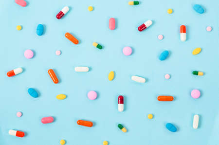 Colorful pill tablets on blue background.の写真素材