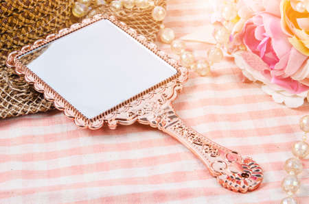 Vintage makeup mirror with flower on table.の写真素材
