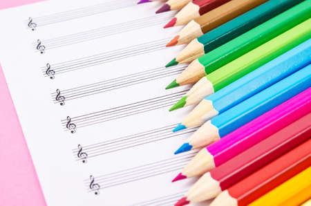 color pencils and blank musical notes background.の写真素材