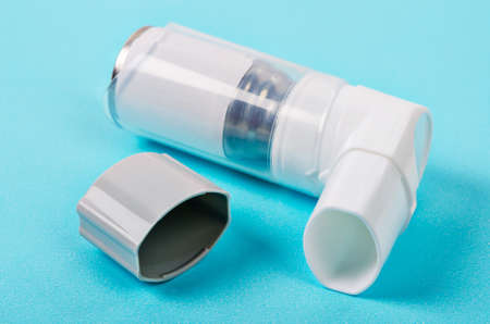 white asthma inhaler on blue background.の写真素材