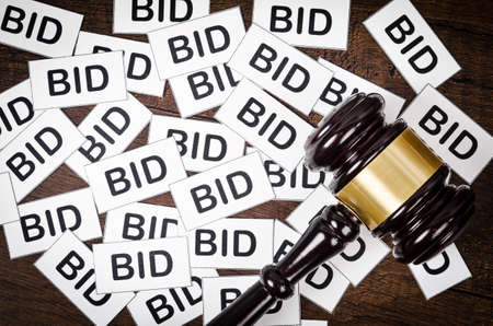 One gavel like those used on auctioning with the word bid on wooden background.の写真素材