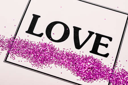 LOVE word with glitter in frame on beautiful paper background, Valentine's day concept.の写真素材